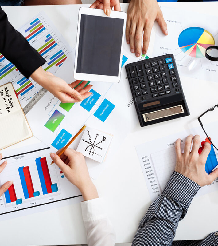 Picture of businessmen's hands on white table with documents, coffee and drafts